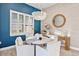 Coastal dining room with modern chandelier, white chairs, decorative mirror, and natural light at 809 Seascape Pl, Sarasota, FL 34240