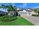 Beautiful single-story home featuring lush landscaping, a paver driveway, and a three-car garage at 809 Seascape Pl, Sarasota, FL 34240