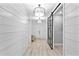 Bright hallway with wooden flooring, shiplap walls, light fixtures and sliding door access at 809 Seascape Pl, Sarasota, FL 34240