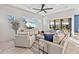 Bright living room with large sofa, stylish decor, ceiling fan, and access to the outdoor patio at 809 Seascape Pl, Sarasota, FL 34240