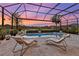 Tranquil screened-in pool area with comfortable lounge chairs and picturesque views of the surrounding neighborhood at 809 Seascape Pl, Sarasota, FL 34240