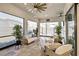Bright sunroom featuring wicker furniture, tiled floors, and expansive windows at 809 Seascape Pl, Sarasota, FL 34240