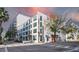 Modern condo building featuring white accents, a red door, lots of windows, and manicured landscaping at 101 N 12Th St # 306, Tampa, FL 33602