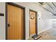 Hallway showing wooden doors to condo units with overhead pipes and concrete flooring at 101 N 12Th St # 306, Tampa, FL 33602