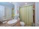 Bright bathroom with a granite countertop vanity, and shower with stylish curtain at 11595 Gulf Blvd # 6, Treasure Island, FL 33706