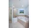 Bathroom featuring a jacuzzi tub, walk-in shower, and stylish fixtures at 11595 Gulf Blvd # 6, Treasure Island, FL 33706
