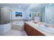 Bathroom featuring a jacuzzi tub, walk-in shower, double sinks, and stylish fixtures at 11595 Gulf Blvd # 6, Treasure Island, FL 33706