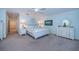 A bright bedroom is decorated with white furniture, carpet, and a ceiling fan at 11595 Gulf Blvd # 6, Treasure Island, FL 33706