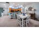 Bright dining area with white table set and bar seating opening up to the kitchen with wood cabinets and blue accent decor at 11595 Gulf Blvd # 6, Treasure Island, FL 33706