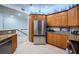 Spacious kitchen with stainless steel refrigerator and wood cabinets with granite countertops leading to the stairs at 11595 Gulf Blvd # 6, Treasure Island, FL 33706