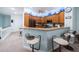 Open kitchen with a breakfast bar, light wood cabinets and a decorative blue accent collection on display above the cabinets at 11595 Gulf Blvd # 6, Treasure Island, FL 33706