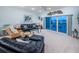 Living room with plush seating, ceiling fan, and a sliding glass door leading to a waterfront balcony at 11595 Gulf Blvd # 6, Treasure Island, FL 33706