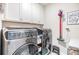 Well-equipped laundry room with modern washer and dryer, ample storage, and convenient layout at 11639 Sweet Tangerine Ln, Tampa, FL 33626