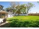 Spacious backyard with lush green grass and a brick patio at 11980 Valencia Ct, Seminole, FL 33772