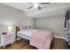 Cozy bedroom with hardwood floors, a ceiling fan, and a nightstand with a lamp at 11980 Valencia Ct, Seminole, FL 33772