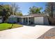 Inviting home boasts a large driveway, attached garage and covered porch with cozy blue chairs at 11980 Valencia Ct, Seminole, FL 33772