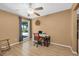A functional home office space with wood floors, a desk and chair, ceiling fan, and natural light at 11980 Valencia Ct, Seminole, FL 33772