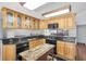 Well-lit kitchen with stainless steel refrigerator, granite countertops, wooden cabinets and center island with black appliances at 11980 Valencia Ct, Seminole, FL 33772