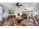 Open concept living room with a fireplace, ceiling fans and hardwood floors, perfect for entertaining at 11980 Valencia Ct, Seminole, FL 33772