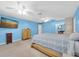 Bright main bedroom featuring blue walls, ceiling fans, neutral carpeting, bedroom dresser, TV at 11980 Valencia Ct, Seminole, FL 33772