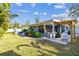 Inviting backyard with a covered patio, lush landscaping, and a neatly manicured lawn at 1269 80Th N Ave, St Petersburg, FL 33702