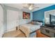 Small bedroom with blue accent wall, carpet floor, ceiling fan, and double door closet at 1269 80Th N Ave, St Petersburg, FL 33702