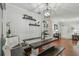 Light dining area with white-painted bench seating and dark table. Overhead decorative light fixture at 1269 80Th N Ave, St Petersburg, FL 33702