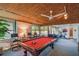 Large, carpeted game room with billiards table, ceiling fan, and casual seating area at 1269 80Th N Ave, St Petersburg, FL 33702