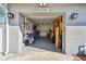 A well lit garage with laundry, shelving, tools and bikes inside a light grey garage door at 1269 80Th N Ave, St Petersburg, FL 33702