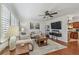 Bright living room featuring hardwood floors, neutral paint, large windows with shutters, and seamless flow to the kitchen at 1269 80Th N Ave, St Petersburg, FL 33702