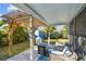 Cozy covered patio with stylish outdoor furniture and a grill overlooking the landscaped backyard at 1269 80Th N Ave, St Petersburg, FL 33702