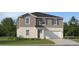 Charming two-story home with a well-manicured lawn, a two-car garage, and tasteful gray and white exterior paint at 13162 Goldstone Ct, Wimauma, FL 33598
