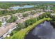 Overhead shot of townhomes next to a serene lake and lush greenery, showcasing a peaceful residential setting at 14542 Mirabelle Vista Cir, Tampa, FL 33626