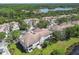 Scenic aerial view of townhomes with lush landscaping, community pond, and mature trees creating a serene setting at 14542 Mirabelle Vista Cir, Tampa, FL 33626