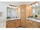 Bathroom featuring double vanity, marble countertops, with storage, and well-lit mirrors at 14542 Mirabelle Vista Cir, Tampa, FL 33626