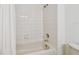 Bathroom features a bathtub with tiled walls, shower head, and white shower curtain at 14542 Mirabelle Vista Cir, Tampa, FL 33626
