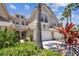 Charming multi-story home with a two-car garage, landscaped yard, and tropical foliage at 14542 Mirabelle Vista Cir, Tampa, FL 33626