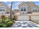 Charming two-story townhouse featuring an attached garage, manicured landscaping, and a tile roof at 14542 Mirabelle Vista Cir, Tampa, FL 33626