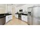 Bright kitchen featuring stainless steel appliances, white cabinets, and dark countertops at 14542 Mirabelle Vista Cir, Tampa, FL 33626