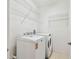 Functional laundry room with modern washer, dryer, and storage shelving at 14542 Mirabelle Vista Cir, Tampa, FL 33626