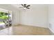 Open living area with tile floors, ceiling fan, and access to outdoor patio with pool view at 14542 Mirabelle Vista Cir, Tampa, FL 33626
