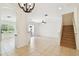 Bright living room featuring tile flooring, staircase, and sliding glass doors to outdoor patio at 14542 Mirabelle Vista Cir, Tampa, FL 33626