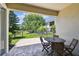 Relaxing outdoor patio with a table and chairs overlooking a fenced backyard and pond at 14542 Mirabelle Vista Cir, Tampa, FL 33626