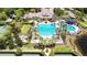 Aerial view of a large community pool, clubhouse, tennis courts, and lush landscaping, offering resort-style amenities at 14542 Mirabelle Vista Cir, Tampa, FL 33626