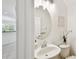 Stylish powder room with an oval mirror, decorative lighting, and a pedestal sink at 14542 Mirabelle Vista Cir, Tampa, FL 33626