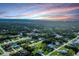 An aerial shot of a residential area surrounded by dense woods, under a beautiful colorful sky at 15099 Community Ave, Port Charlotte, FL 33953
