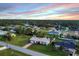 A beautiful neighborhood with well-maintained lawns and mature trees, set against a colorful evening sky at 15099 Community Ave, Port Charlotte, FL 33953