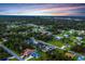 Aerial view of a neighborhood with mature trees, some canals, and homes with pools at 15099 Community Ave, Port Charlotte, FL 33953