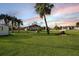 Large backyard with green grass and scattered palm trees at 15099 Community Ave, Port Charlotte, FL 33953