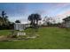 Expansive backyard with lush green grass, palm trees, and a storage shed at 15099 Community Ave, Port Charlotte, FL 33953